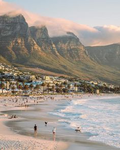 people on the beach with mountains in the background