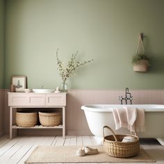 a white bath tub sitting next to a wooden table with baskets on top of it