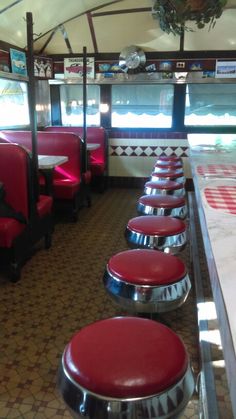 the inside of a diner with red seats