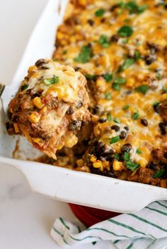 a casserole dish with meat, cheese and vegetables in it next to a fork