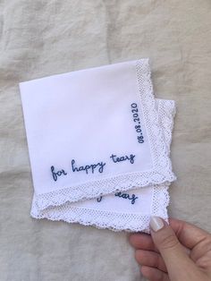 two white handkerchiefs with embroidered words on them, one saying for happy today and the other saying for always