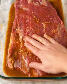 a person is touching the meat on top of it