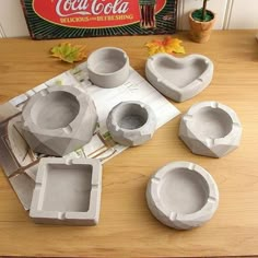 four cement molds sitting on top of a table next to an old coca cola sign