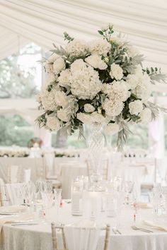 the centerpieces are arranged in clear vases with greenery and white flowers