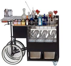 a bar cart with wine glasses and liquor bottles