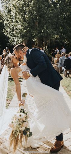 a bride and groom kissing in front of an outdoor ceremony