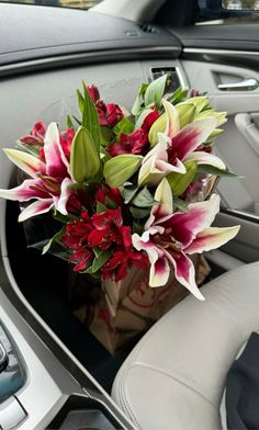 a bouquet of flowers sitting in the center console of a car