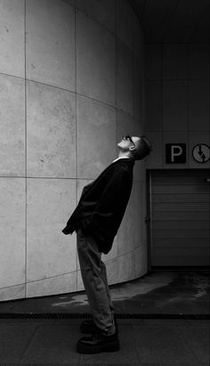 a man standing in front of a wall with his head up to the ceiling and eyes closed