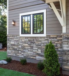 the side of a house with a stone wall and window on it's side