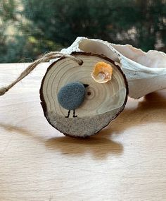 a small bird sitting on top of a piece of wood next to a tree slice