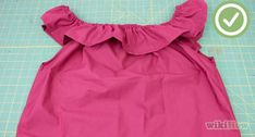 the back of a pink dress with ruffles on it, sitting on a cutting board