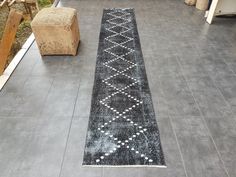 a black and white runner rug sitting on top of a floor next to a bench