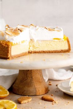 a piece of cake on a plate with lemons around it and another slice in the background