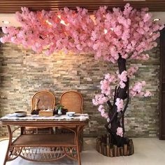 a dining room with a table and chairs under a pink tree