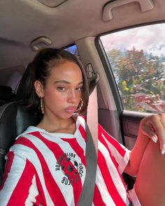 a woman sitting in the back seat of a car with her hand on her hip