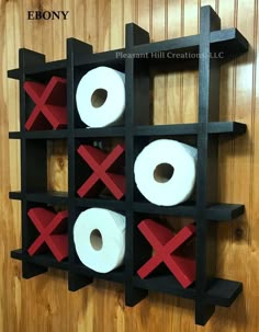 two rolls of toilet paper sitting on top of a black shelf with red x's