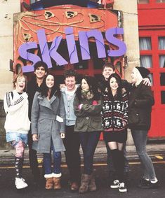 black and white photograph of young people standing in front of a building with the words skis on it