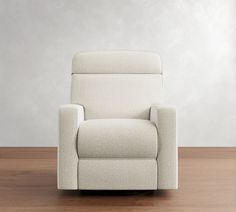 a white recliner chair sitting on top of a wooden floor next to a wall