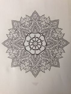 a black and white drawing of a flower on a sheet of paper with an intricate design