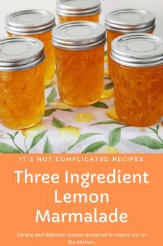 four jars filled with lemon marmalade sitting on top of a floral table cloth