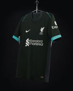 the new liverpool away shirt is hanging on a hanger in front of a black background