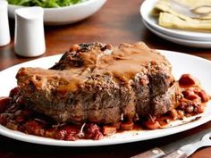 a white plate topped with meat covered in gravy