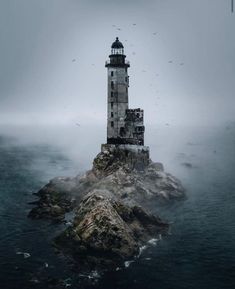 a light house sitting on top of a small island in the middle of the ocean