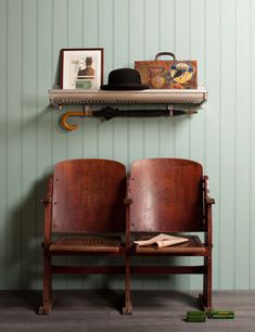 two brown leather seats sitting on top of a shelf next to a bag and purse