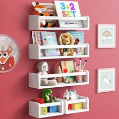 a wall mounted shelf with books, toys and pictures on it next to a pink wall