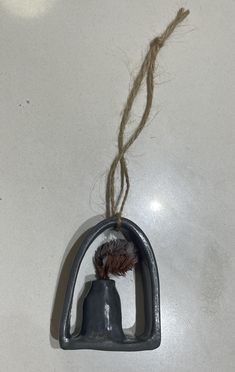 a bell ornament hanging from a rope on a table with a piece of string attached to it