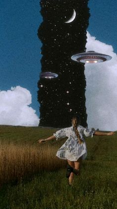 a woman is running in the grass with two flying objects above her