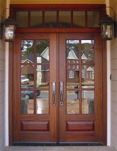 the front door to a home with two lights on each side