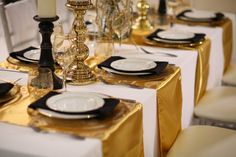 the table is set with black and gold place settings