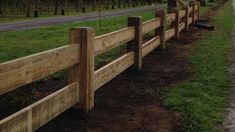 a wooden fence along the side of a road