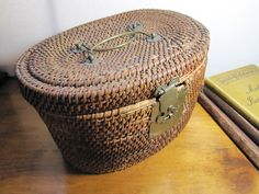 an old wicker basket sitting on top of a wooden table next to two books