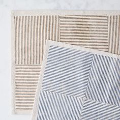 two blue and white striped rugs sitting on top of each other next to each other