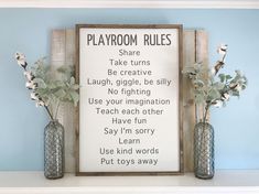 two vases filled with flowers sitting on top of a shelf next to a sign that says playroom rules