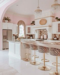 a pink and white kitchen with leopard print stools