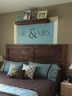 a bed with blue and brown comforter in a bedroom next to a sign that says mr & mrs