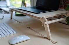 a laptop computer sitting on top of a wooden desk next to a mouse and keyboard