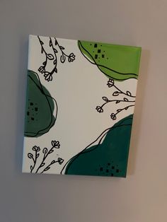 a green and white painting hanging on the wall