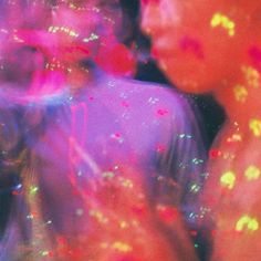 two men standing next to each other with colored powder on their faces and hands in front of them