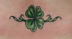 a four - leaf clover tattoo on the back of a woman's stomach,