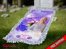 a memorial stone with a photo of a woman and flowers on it in the grass