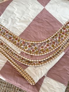 three pieces of pink and white quilted material on top of each other with different patterns