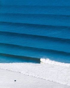 a man riding a wave on top of a surfboard in front of the ocean