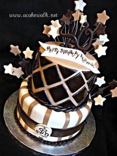 a birthday cake decorated with chocolate and white icing, stars and ribbons on top