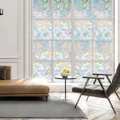 a living room filled with furniture and a large window covered in colorful stained glass panels