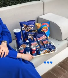 a woman sitting on a bench with snacks and drinks