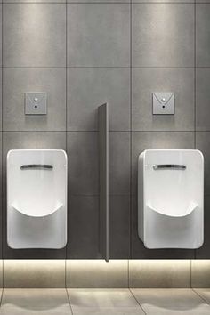 three urinals in a public restroom with tile flooring and walls lined with gray tiles